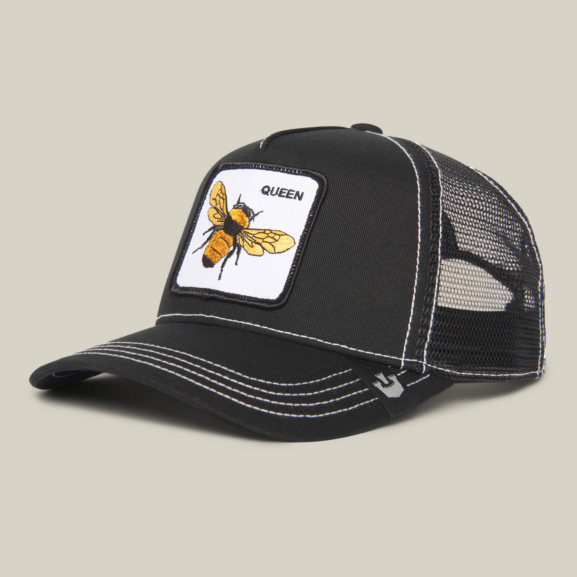 The Farm’s “The Queen Bee” is a black mesh trucker hat with white stitching, a yellow bee patch, and QUEEN on the front—perfect for showing off your crown with pride.