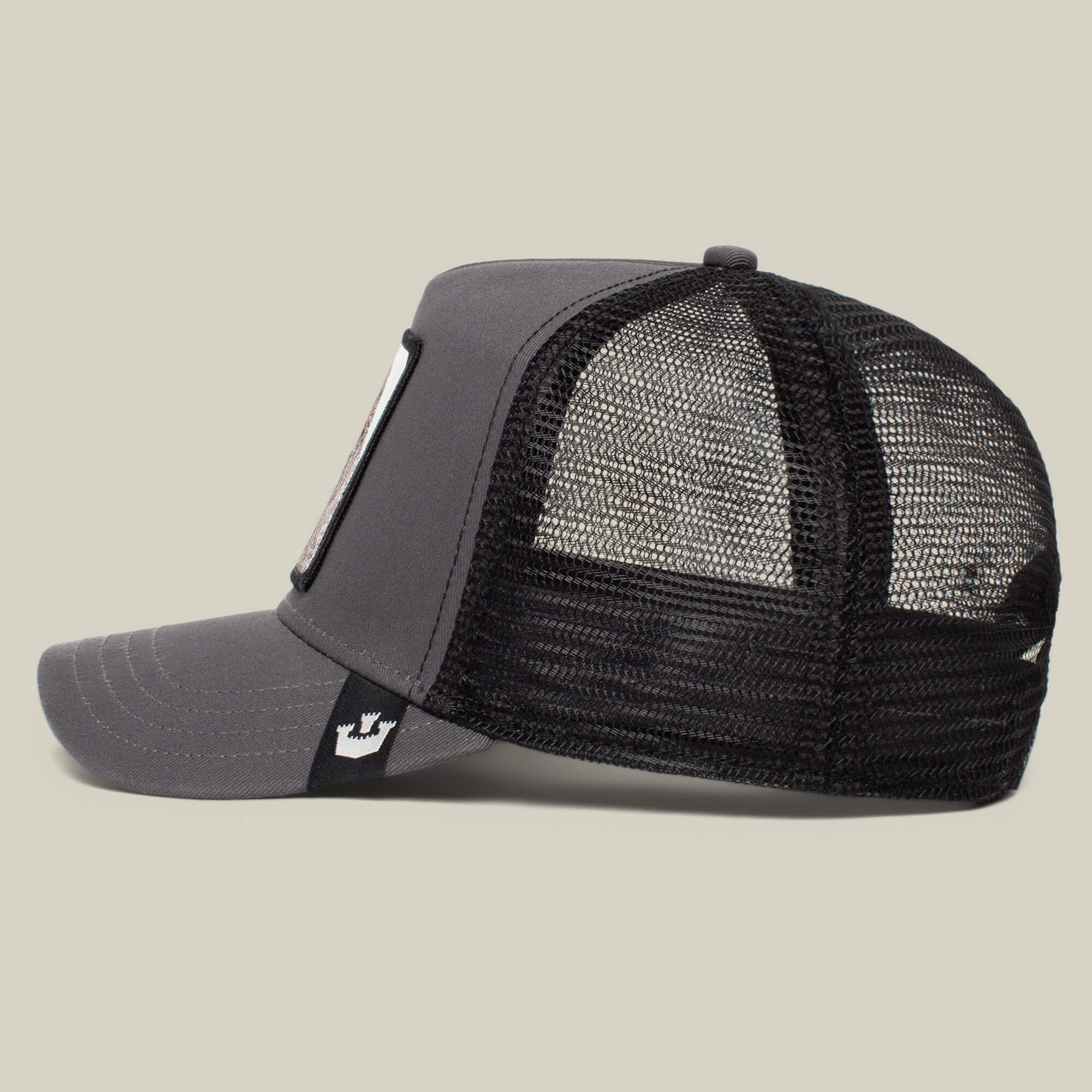 A gray and black mesh-back trucker hat from The Farm, called The Boss, viewed from the side against a plain background—casual style ready to join your collection.