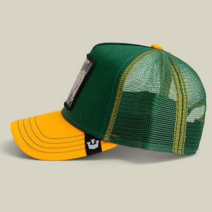 The Farm's "The Bulletproof Rhino" is a green and yellow trucker hat with mesh back, front patch, and black tag with a white animal logo, shown on a plain background. All sales are final.