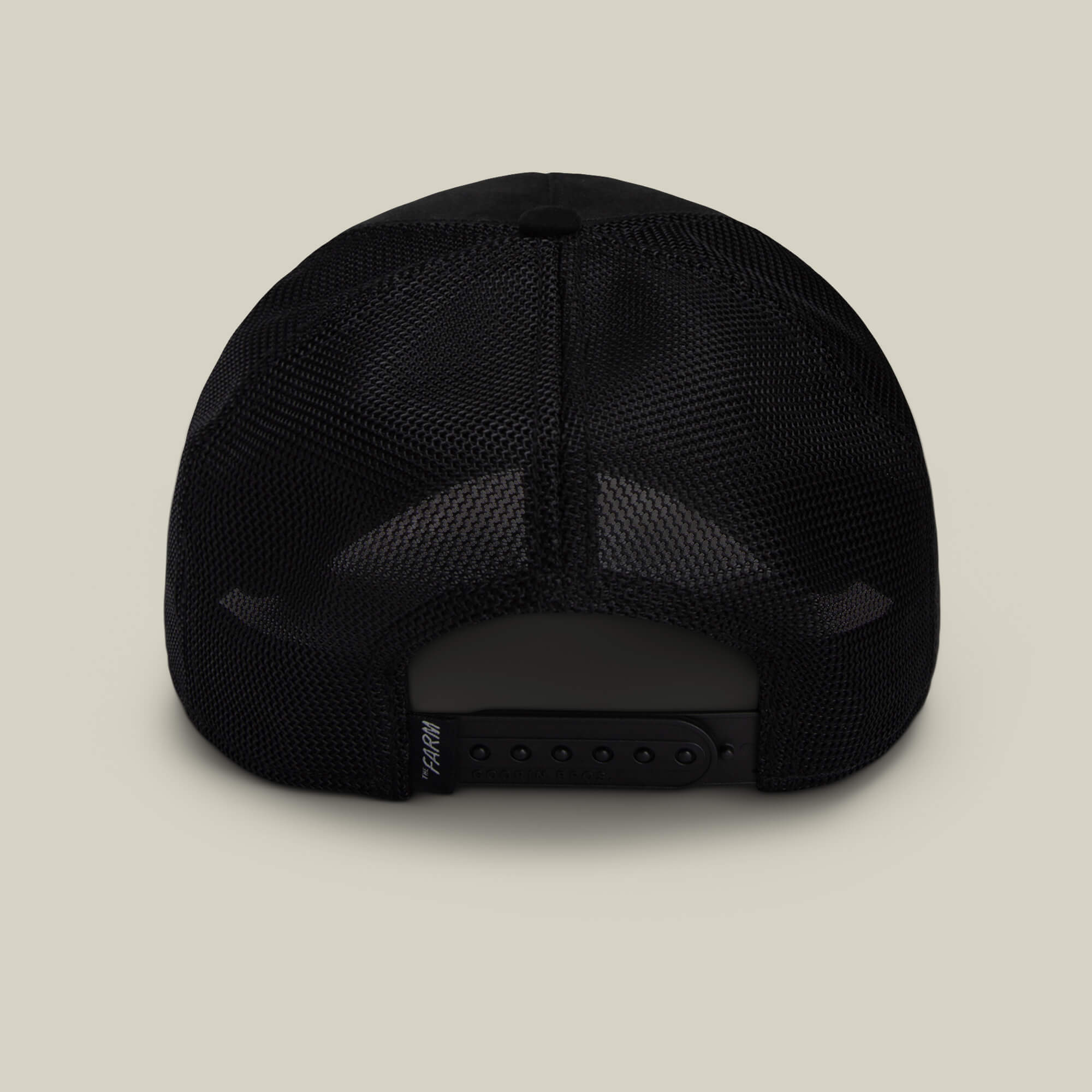 The Suede Spider by Goorin Bros. is a black mesh trucker hat shown from the back with an adjustable snapback closure against a beige background—a funny dad gift.