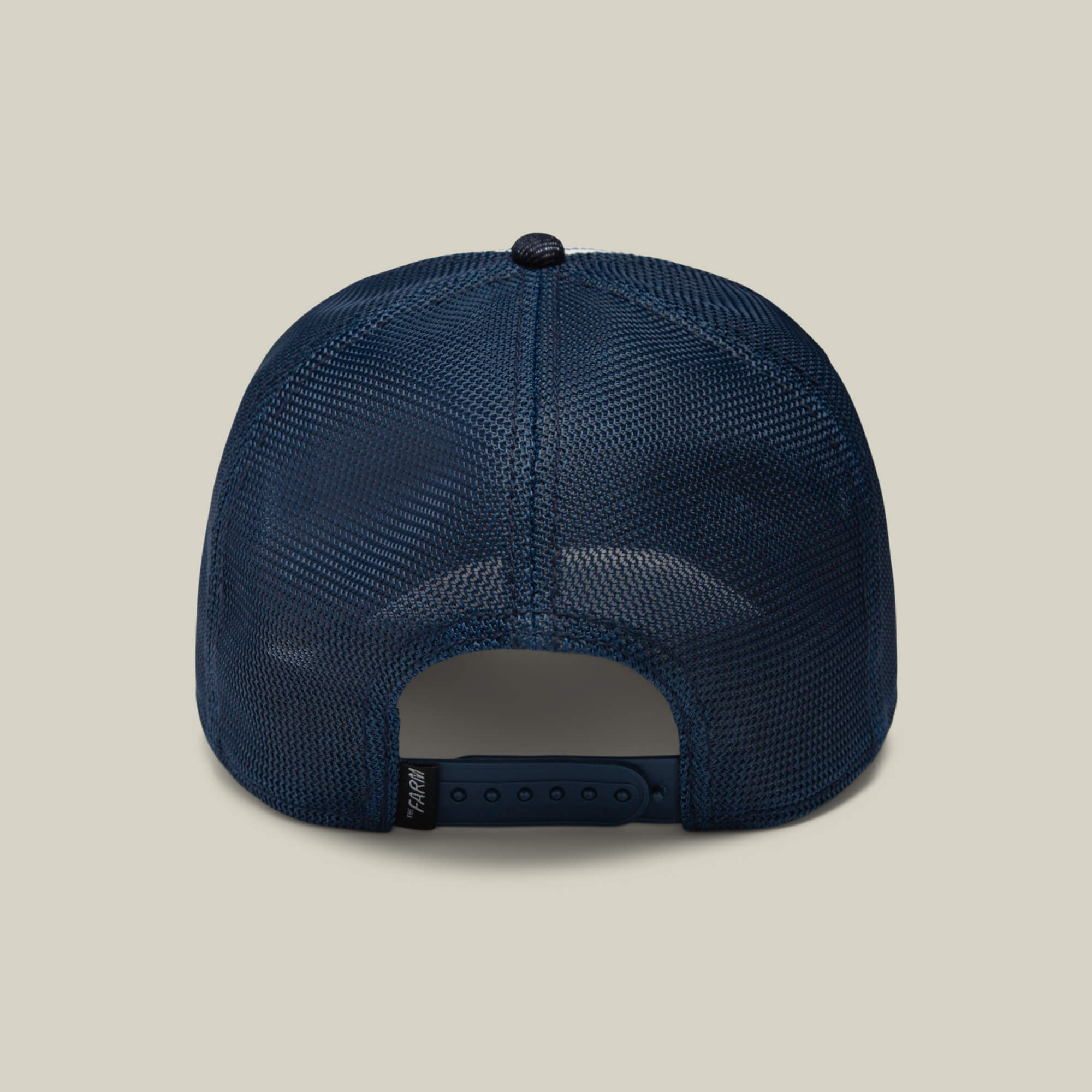 The Farm's "The Bandit Coyote" is a navy mesh baseball cap with an adjustable snapback, pictured from the back against a beige background—ideal for those with a wild spirit.