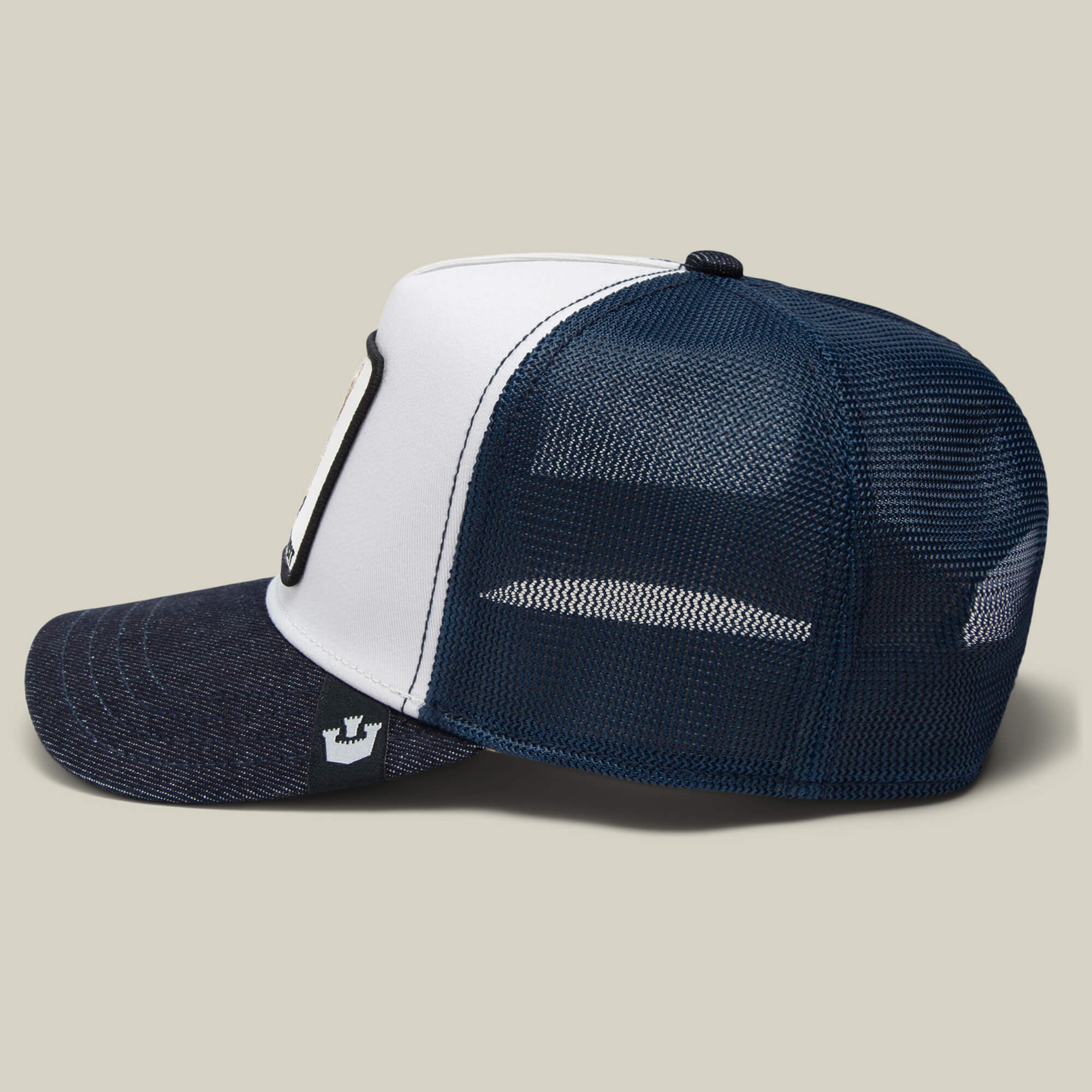 The Bandit Coyote by The Farm is a navy blue and white mesh trucker hat, shown from the side on a neutral background, exuding wild spirit.