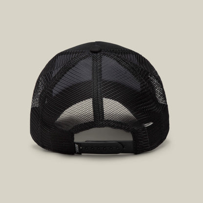 The image displays the back of a black mesh Goorin Bros. EK65 Penguin trucker cap with an adjustable snapback, set against a plain light background. This cap is part of a limited drop collection.