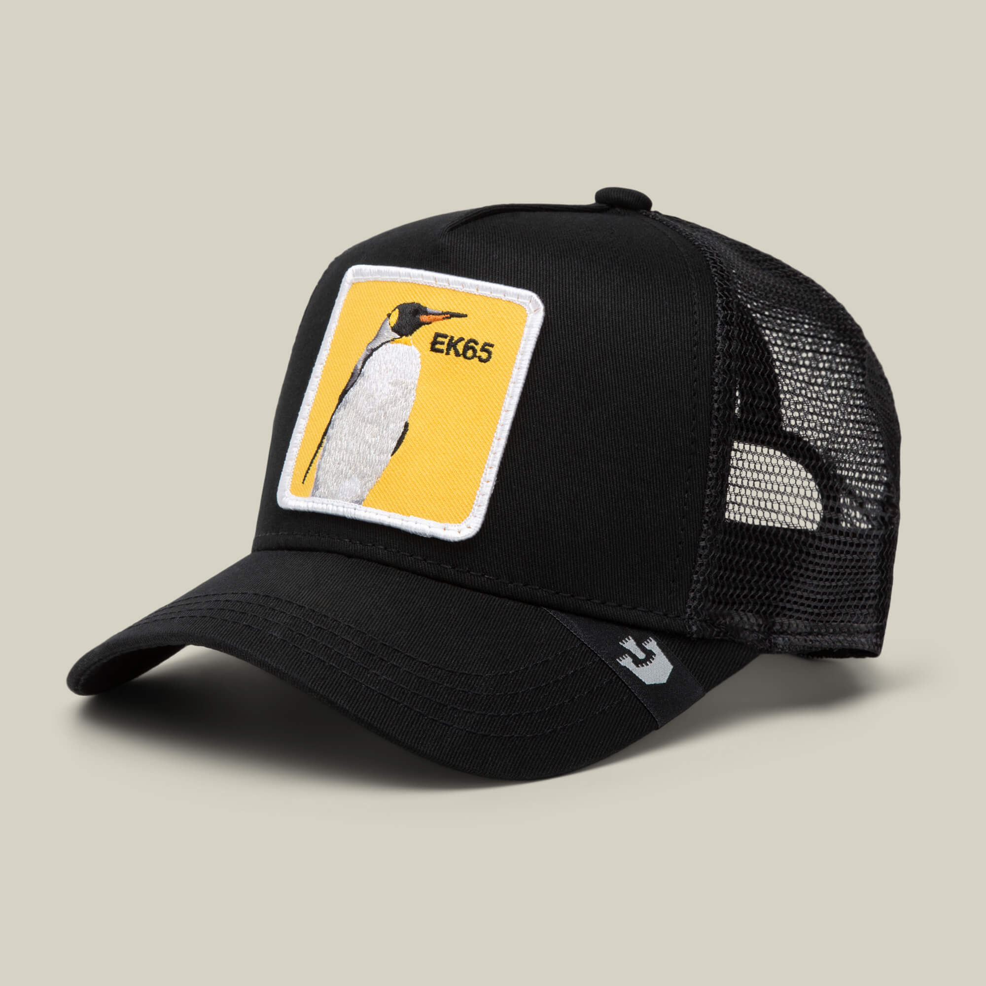 The EK65 Penguin by Goorin Bros. is a black mesh trucker hat with a curved bill, finished with a yellow penguin patch on the front—part of a limited drop inspired by classic Goorin Bros. style.