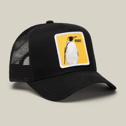 The Goorin Bros. EK65 Penguin is a black mesh trucker hat with a yellow penguin patch and EK65 text on the front, displayed against a light background. Grab this limited edition before it’s gone!.