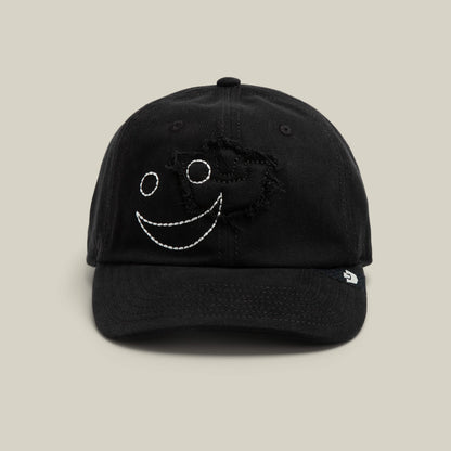 The Fine Headwear cap by Goorin Bros. in VOID color features a stitched white smiley face and distressed detailing, making it a playful addition to any headwear collection.