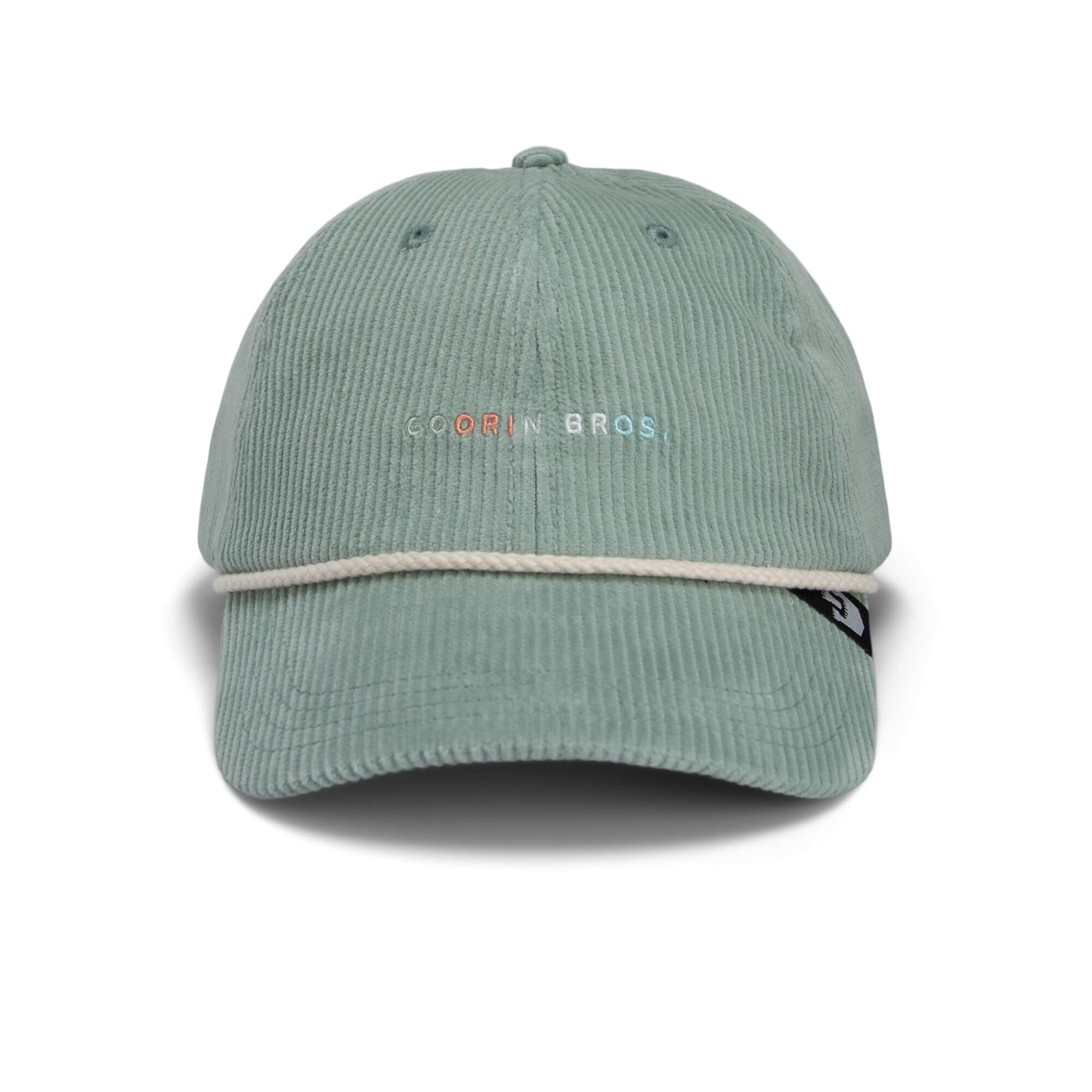 The Clubhouse by Goorin Bros. is a sky blue wide wale corduroy cap with white rope detail, embroidered brand text on the front, and a black side tag—ideal for an understated quiet luxury look.