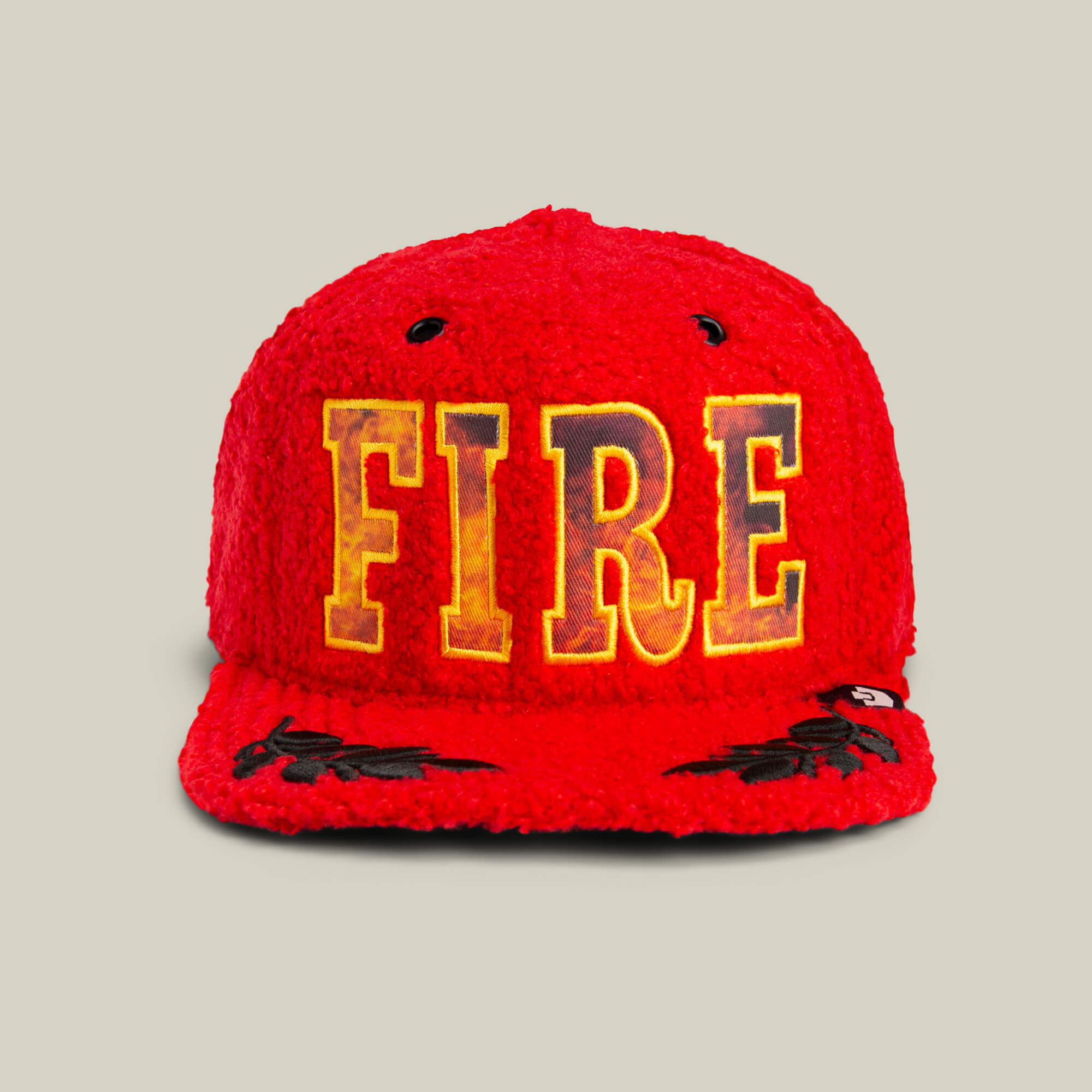 The Hot Fire baseball cap by Goorin Bros. features bright red sherpa fabric, large yellow FIRE lettering on the front, and black flame details by the brim, shown here against a neutral background.