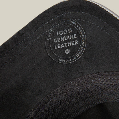 Close-up of the Goorin Bros. LFG Lone Wolf, highlighting its "100% Genuine Leather" label, visible stitching, and textured premium leather material.