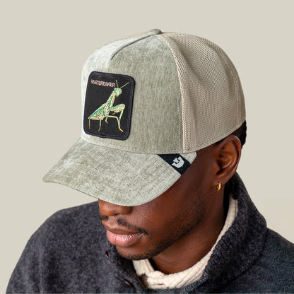 A person wearing the Goorin Bros. Iced Mantis mesh baseball cap in light gray champagne, featuring a patch with a Praying Mantis.