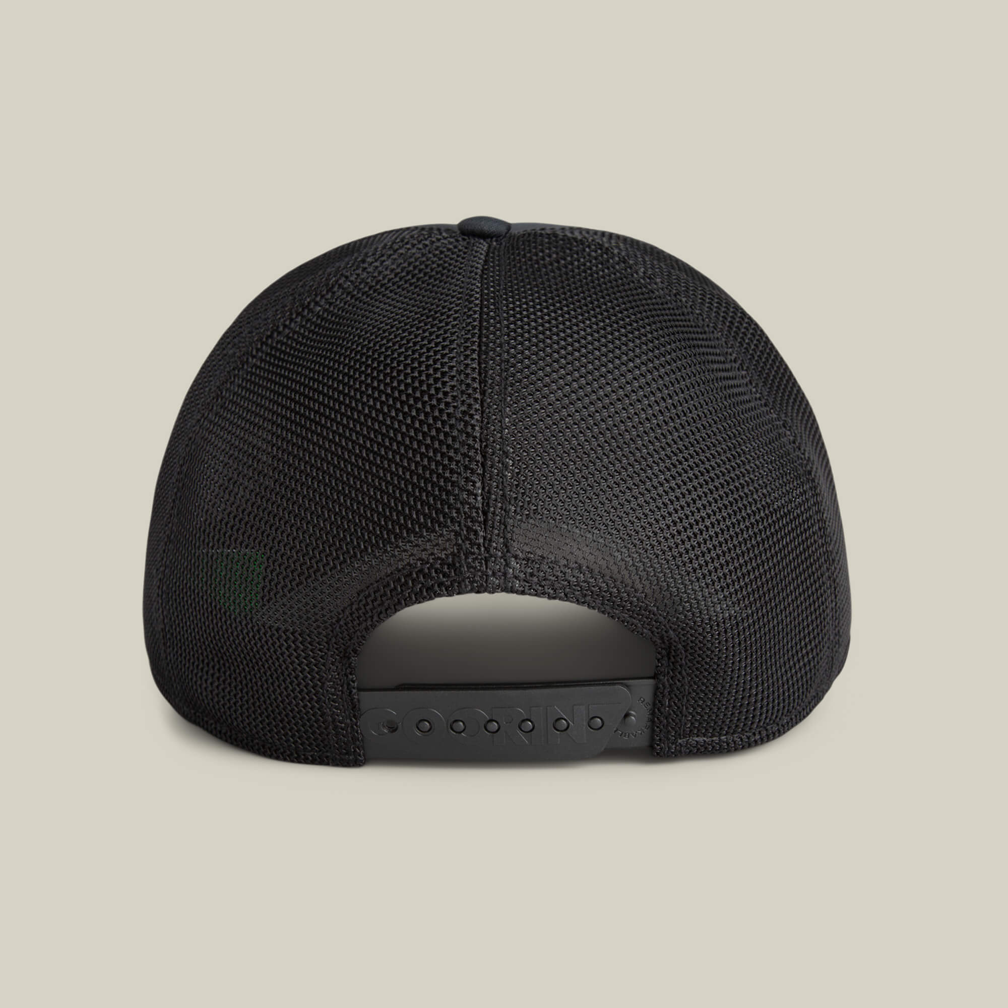 Back view of the Means Yes hat by Goorin Bros., this black mesh trucker features an adjustable snapback closure, displayed on a plain beige background—a distinct fashion accessory.