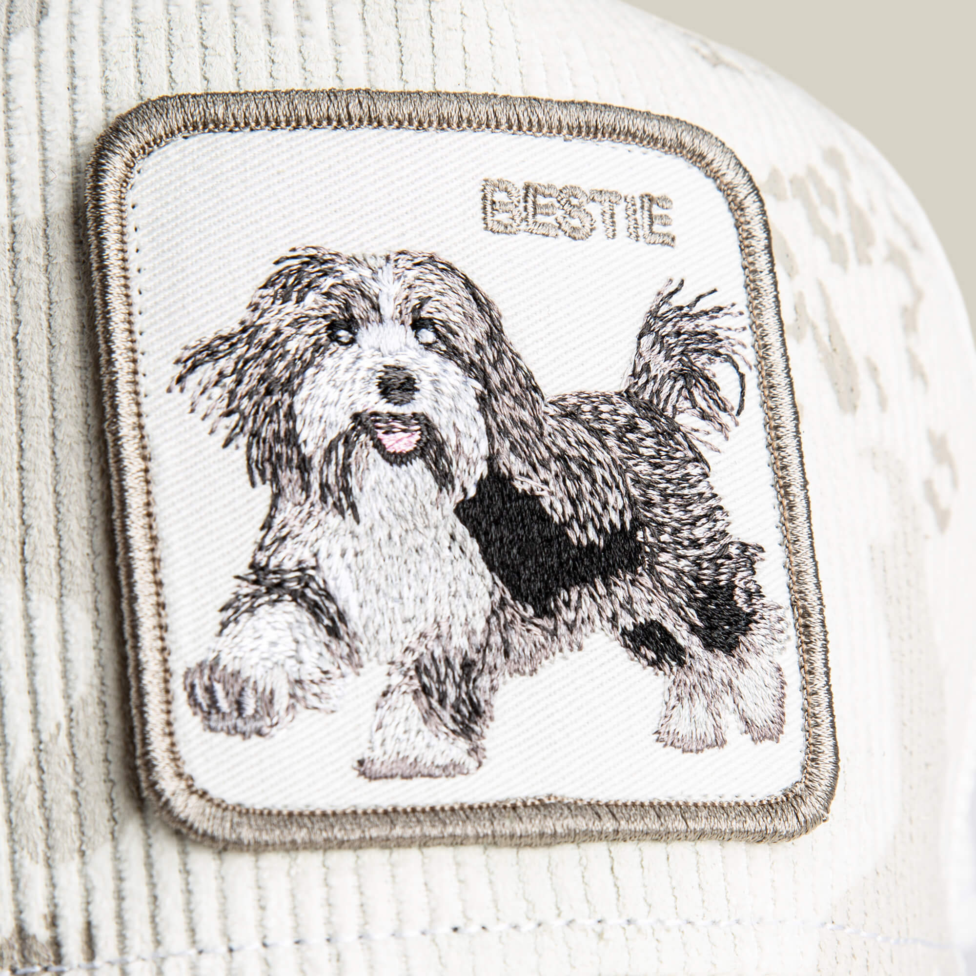 A close-up of the Bestie Camo patch by Goorin Bros., featuring soft corduroy and an embroidered fluffy dog with "BESTIE" above it—ideal for any shaggy pup patch lover.