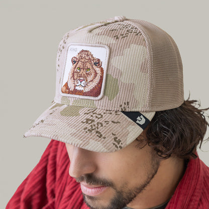 A man in a red shirt wears the Goorin Bros. King Camo beige camouflage mesh cap with a lion face patch, pictured against a plain background.