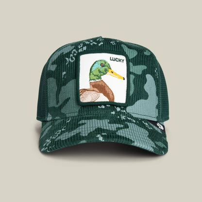 The Goorin Bros. Duck Camo cap is a green camouflage trucker hat with a patch featuring a duck illustration and the word "LUCKY" above it.