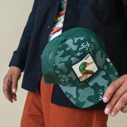 A person holding the Goorin Bros. Duck Camo corduroy hat with a forest green finish and camo patch.