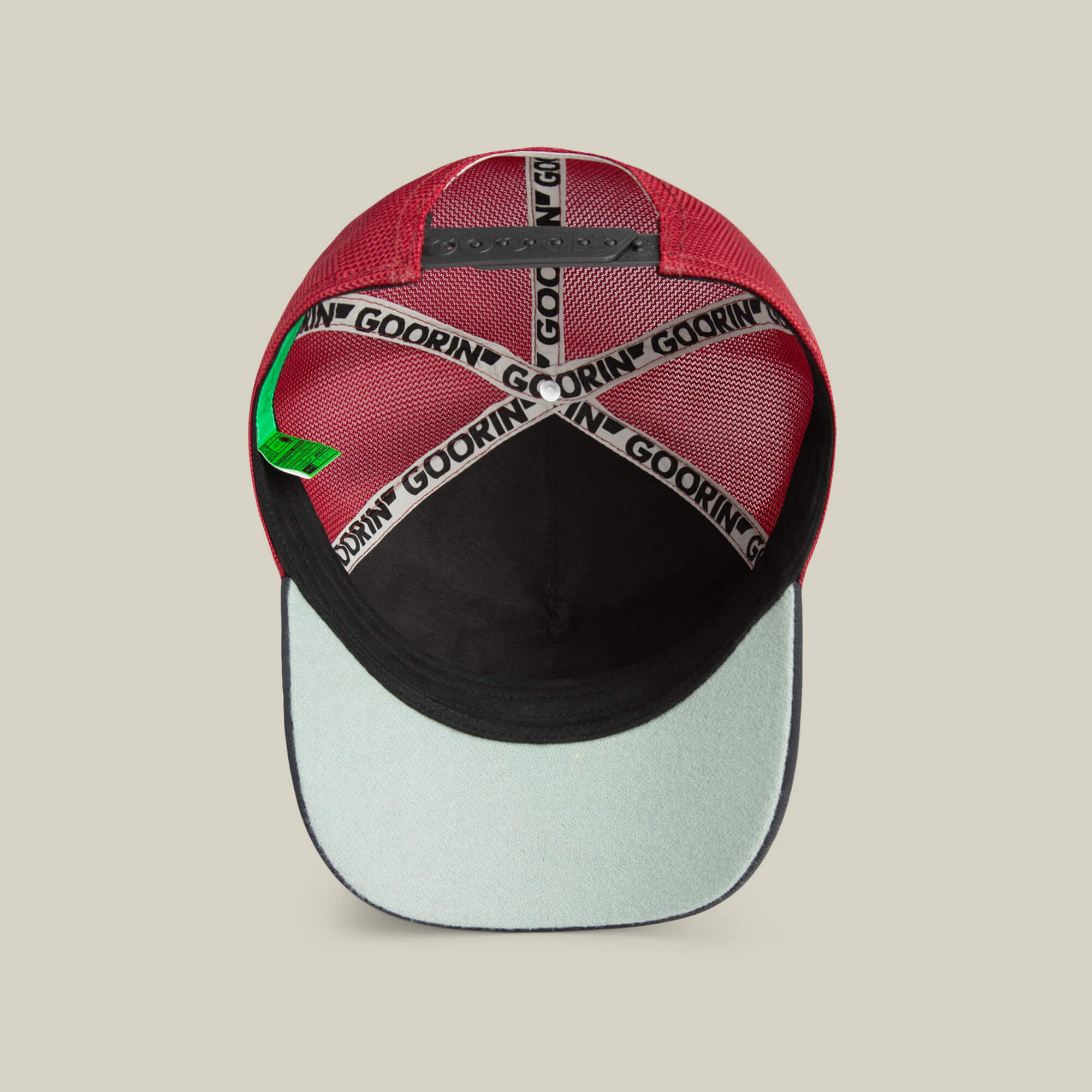 The Means No red baseball cap from Goorin Bros. is shown from underneath, featuring black and white branded tape, a green tag, and a black lining with a light-colored bill—this hat adds unique flair to any look.