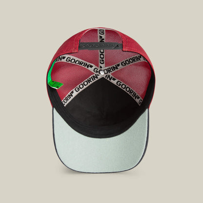 The Means No red baseball cap from Goorin Bros. is shown from underneath, featuring black and white branded tape, a green tag, and a black lining with a light-colored bill—this hat adds unique flair to any look.