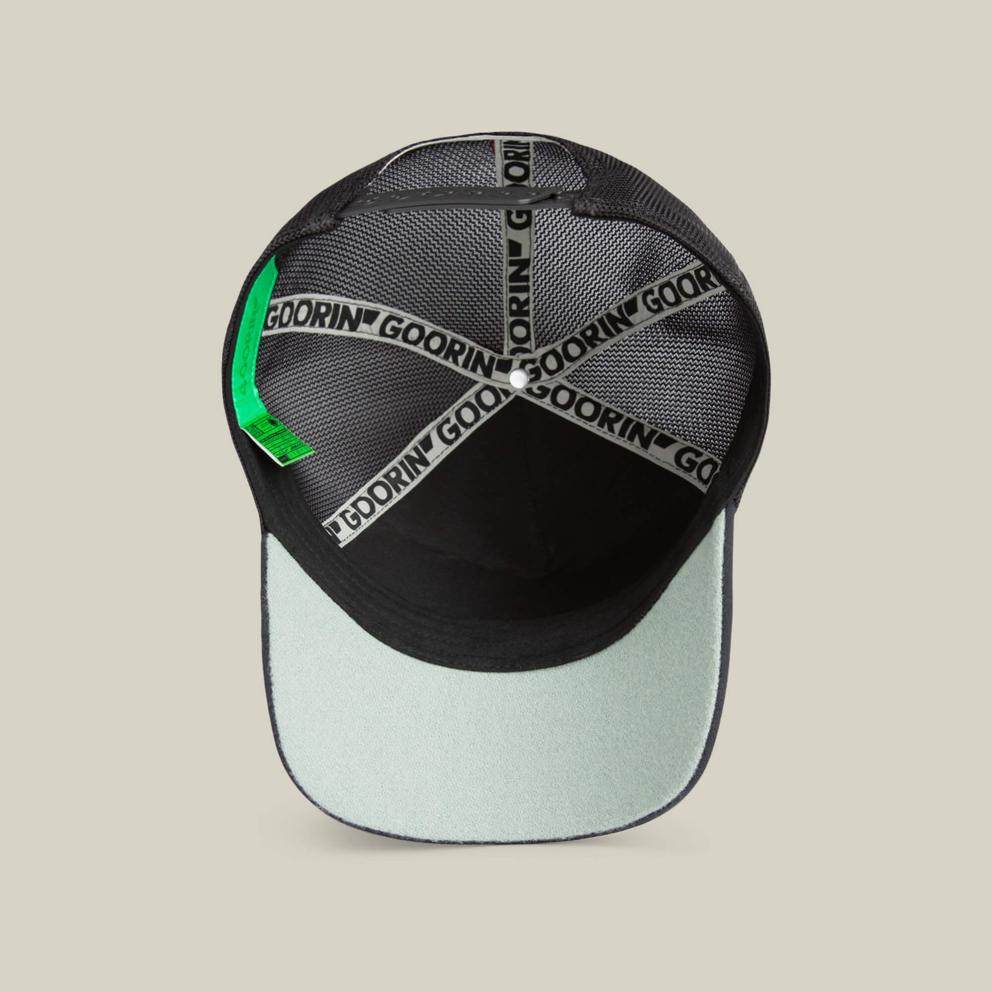 Interior view of the Goorin Means Understood black and light gray baseball hat with mesh panels, branded inner taping, green label, and a sturdy brim for added confidence.