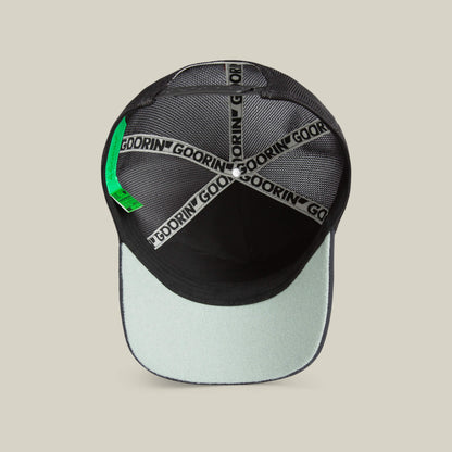 Interior view of the Goorin Means Understood black and light gray baseball hat with mesh panels, branded inner taping, green label, and a sturdy brim for added confidence.