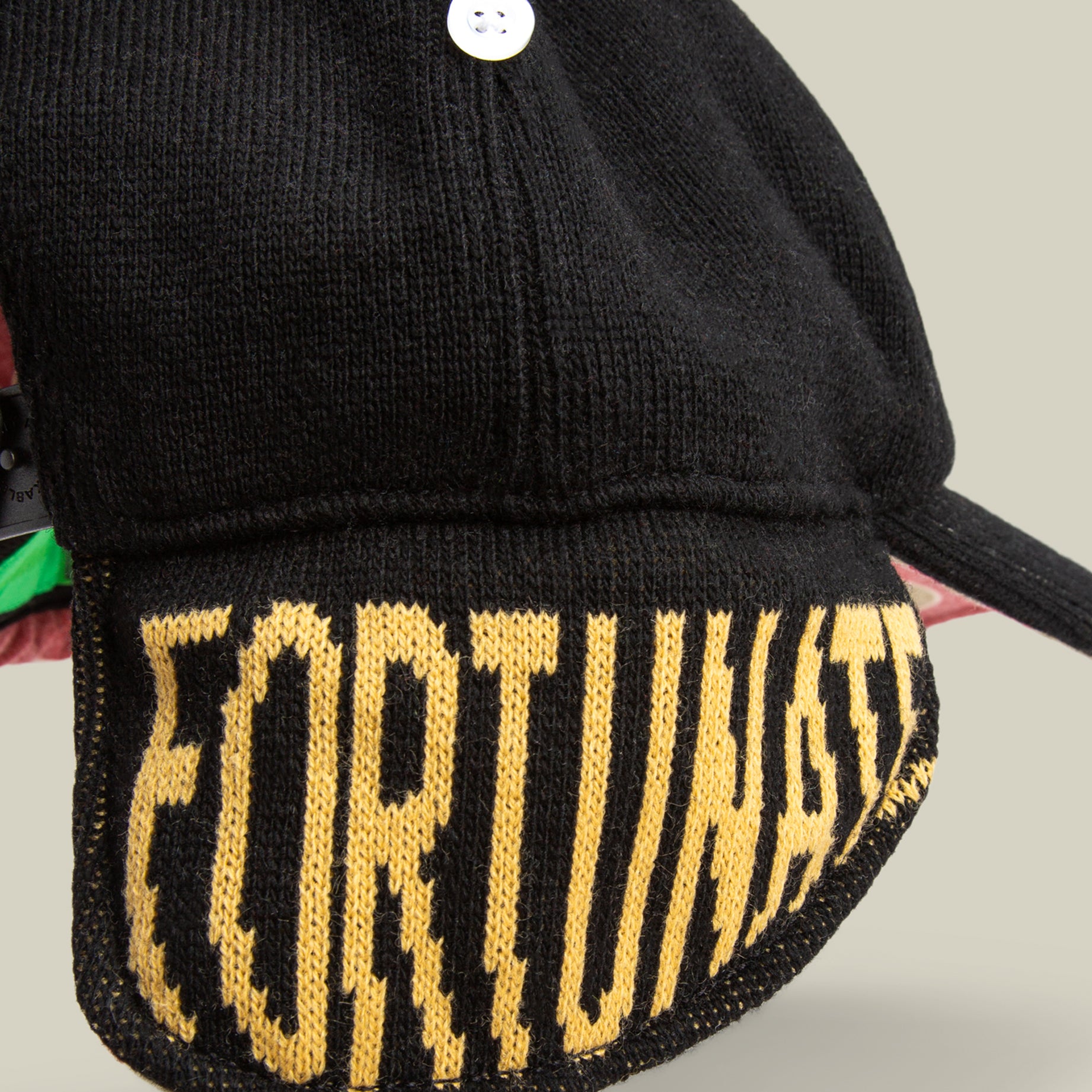 The F is for Fortune knit cap by Goorin Bros. features yellow "FORTUNATE" text on a black brim, showcased against a neutral background.