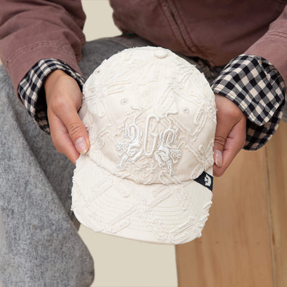 Person holding an off-white "Future Baby Daddy" cap by Goorin Bros., featuring all-over embroidery, a textured pattern, and a visible black tag on the side—perfect for channeling main character energy.