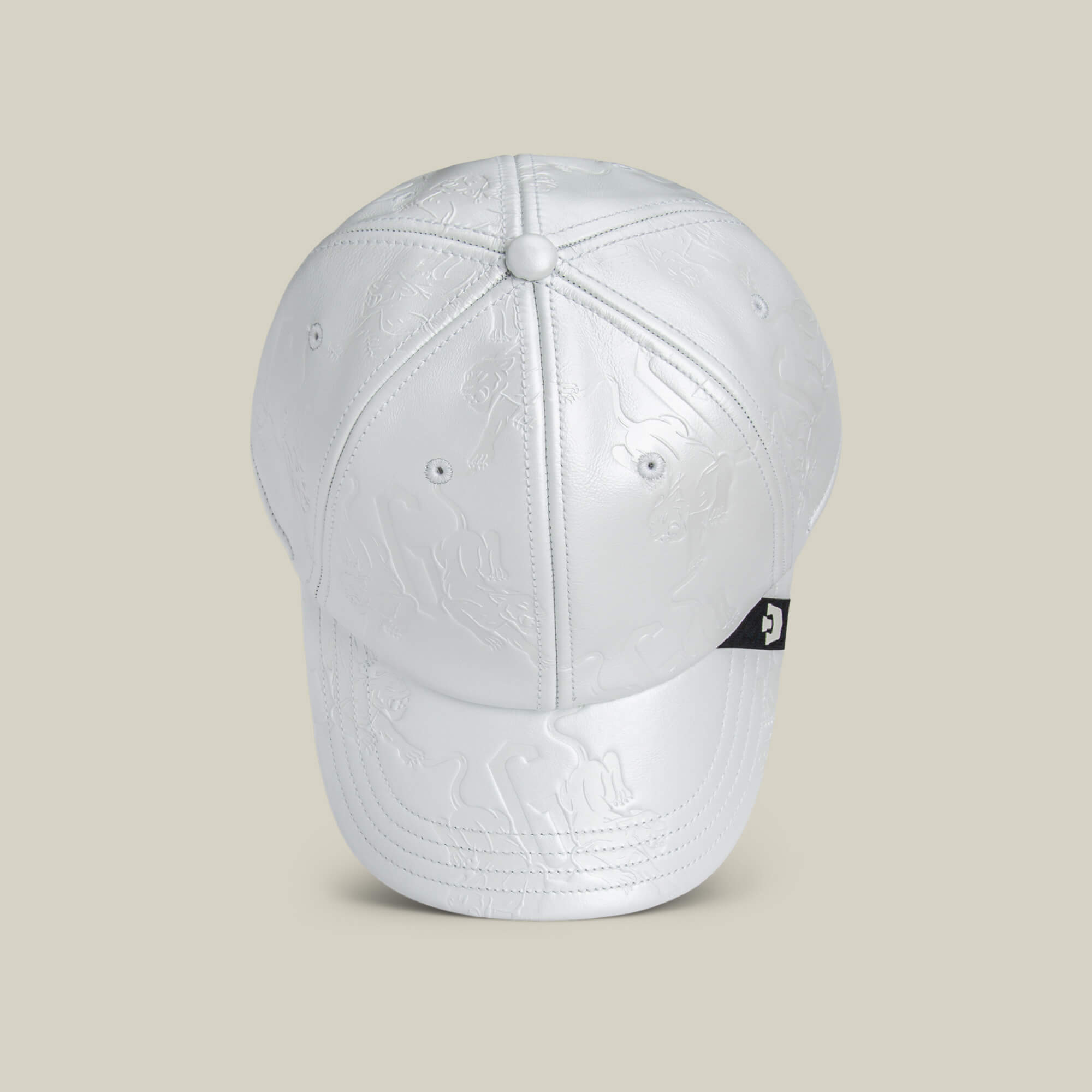 The Put a Panther On It cap by Goorin Bros. features white embossed fabric with subtle patterns, a black logo tag on the side, and offers a classic fit, displayed against a light beige background.