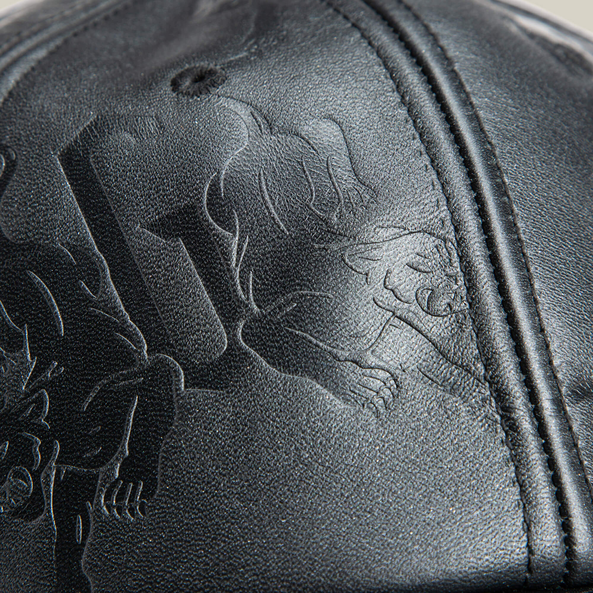 Close-up of the black leather surface on Goorin Bros.’ Put a Panther On It hat, featuring embossed art, stitched seams, and sleek outlines—capturing the refined style of a classic Goorin fit.