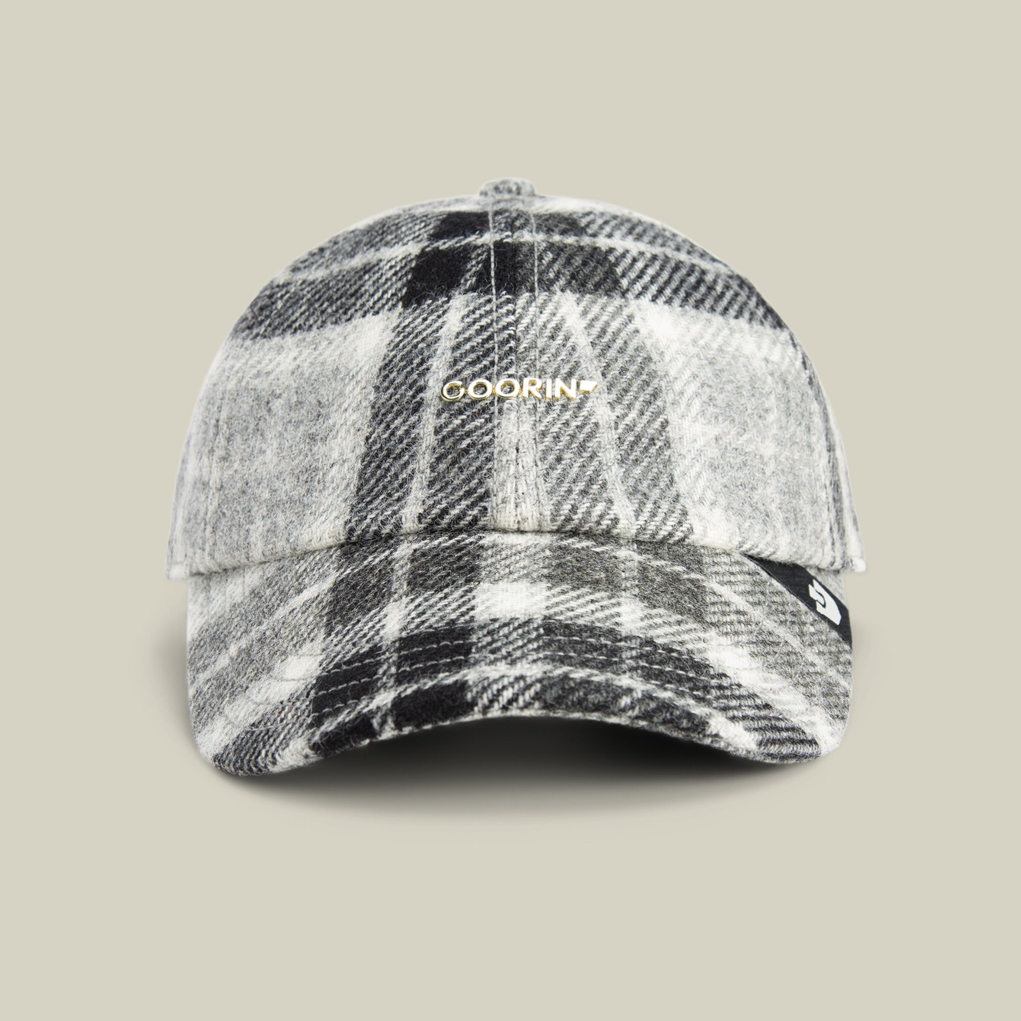 The Goorin Bros. Bespoke Wordmark baseball cap in GLOSS, featuring a standout gold wordmark, is showcased against a plain beige background.