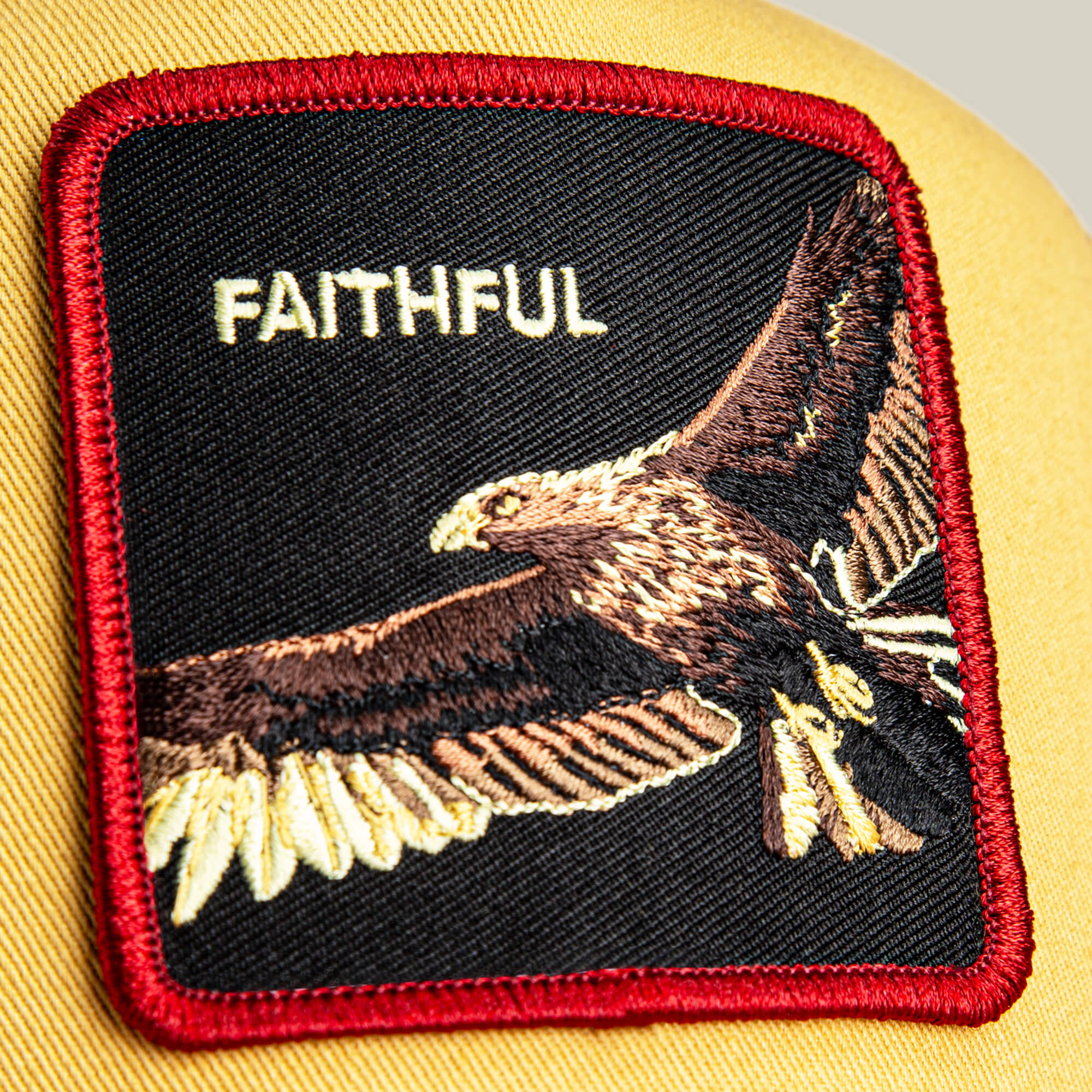 A close-up of The Faithful Eagle patch by Goorin Bros., featuring an embroidered eagle and the word FAITHFUL on yellow—ideal for adding standout style to your favorite cap.