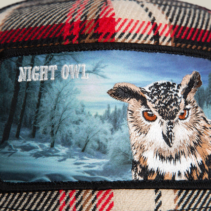 The Goorin Bros. Cabin Fever flannel plaid fabric showcases a patch with an embroidered owl, a wintry forest backdrop, and "NIGHT OWL" in white text, capturing rugged comfort and woodland charm.