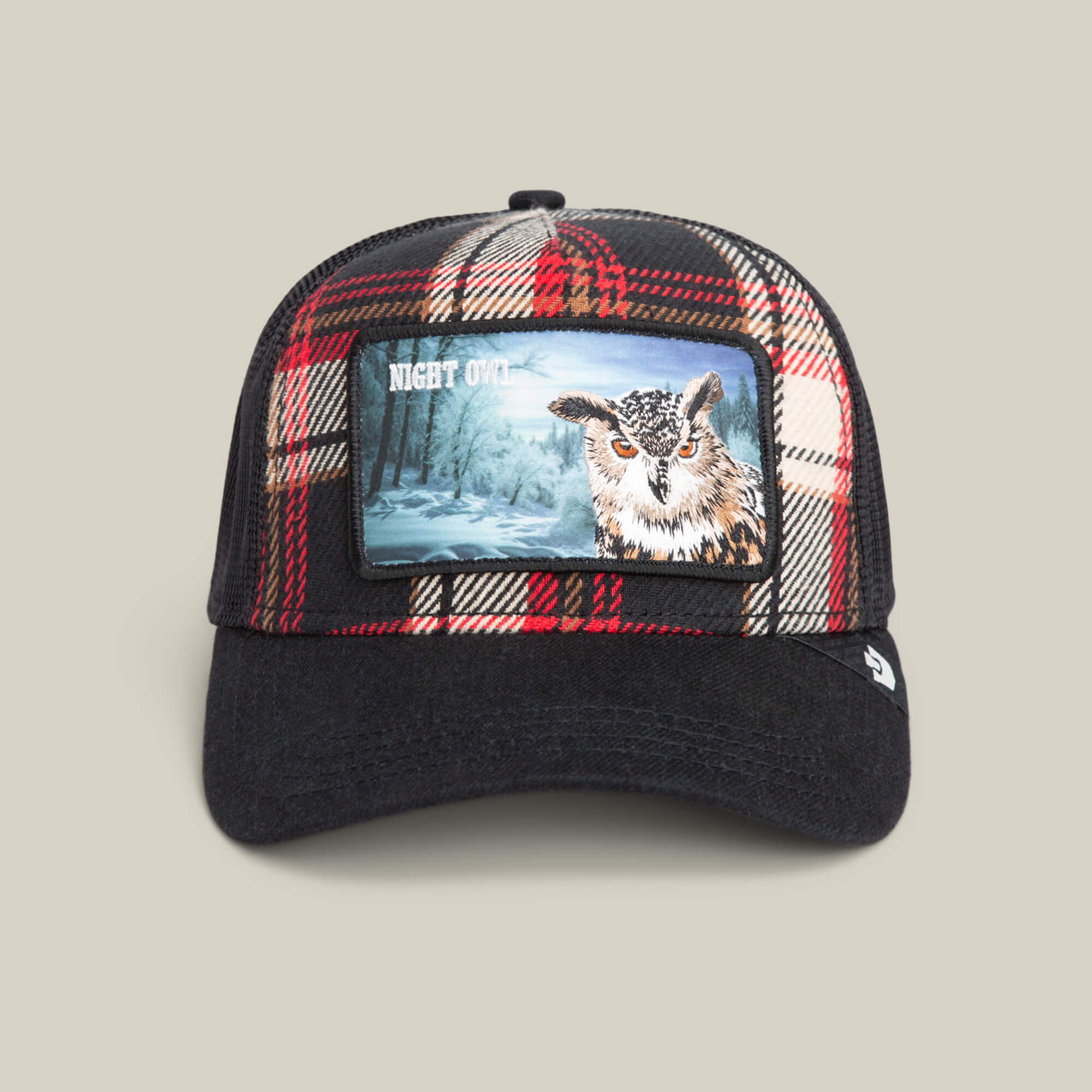 The Goorin Bros. Cabin Fever trucker baseball cap features plaid colors and a front patch with an owl, snowy trees, and "NIGHT OWL" text, offering rugged comfort and style.