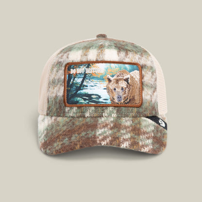 The Goorin Bros. Don't Poke the Bear cap in plaid features a camo flannel design, mesh back, and front patch with a bear and bold "DO NOT DISTURB" text.