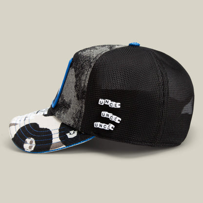 The Goorin Bros. Techno is a black mesh trucker cap featuring a blue and white camouflage front, blue trim, and three UNCE pins—making it the ideal festival fashion statement piece.