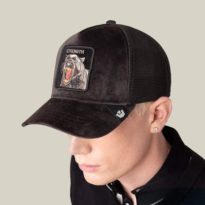 A person wearing the Goorin Bros. Velour Panther hat, a black collared shirt, and a stud earring stands against a plain light background.