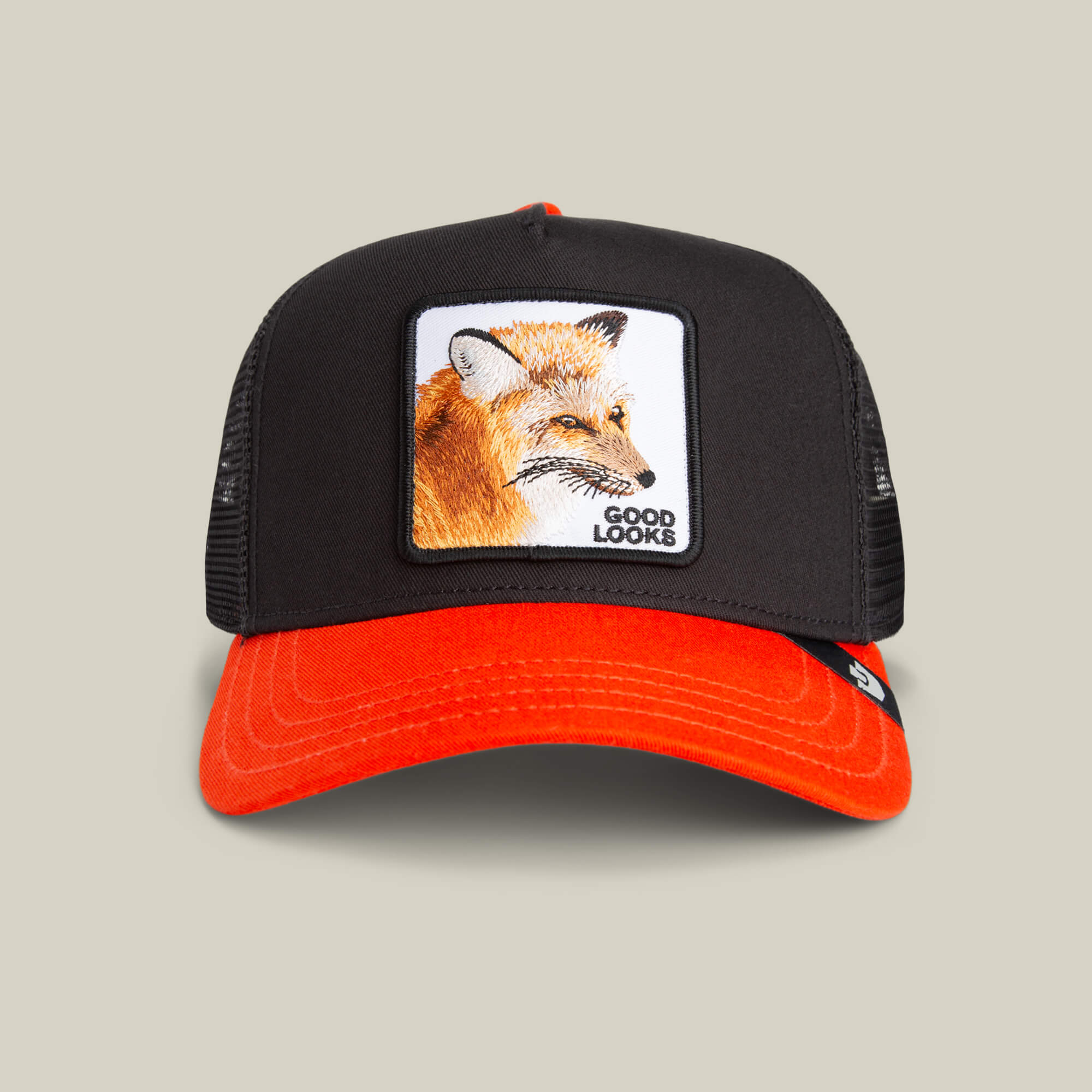 The Goorin Bros. Good Looks Fox trucker hat features a bold black and orange fox illustration with a "Good Looks" patch on the front, offering a stylish take on farmyard chic.