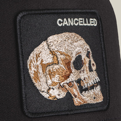 The Cancelled Skull by Goorin Bros. is an embroidered patch with a stitched skull in profile and the word "CANCELLED" above it, set on a black fabric background.