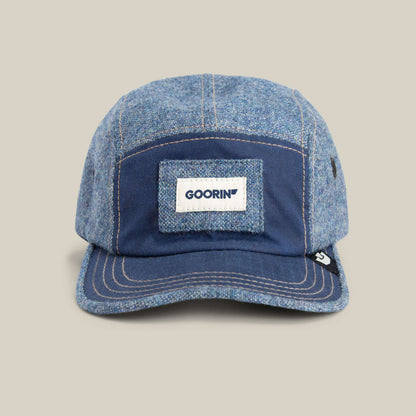 The Goorin Bros. Billed Demand cap in CELESTIAL features a five-panel design, rectangular Goorin patch, and subtle denim texture, shown on a plain beige background.