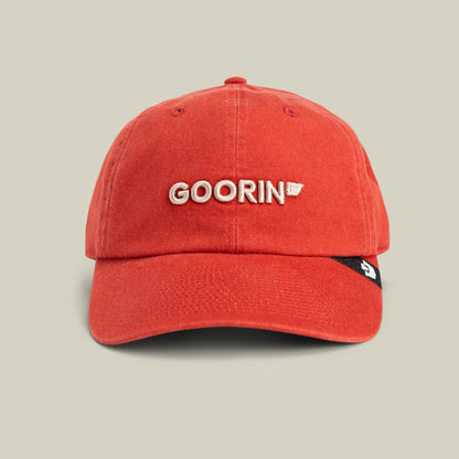 The Goorin Bros. Papa Core is a red embroidered dad hat with white "GOORIN" text and a small logo patch, displayed on a neutral beige background.