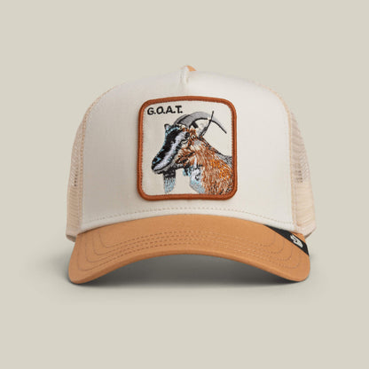 The Goorin Bros. "The G.O.A.T" trucker hat in CHALK / HEAT features a mesh back and a bold front patch with an embroidered goat and the text "G.O.A.T.