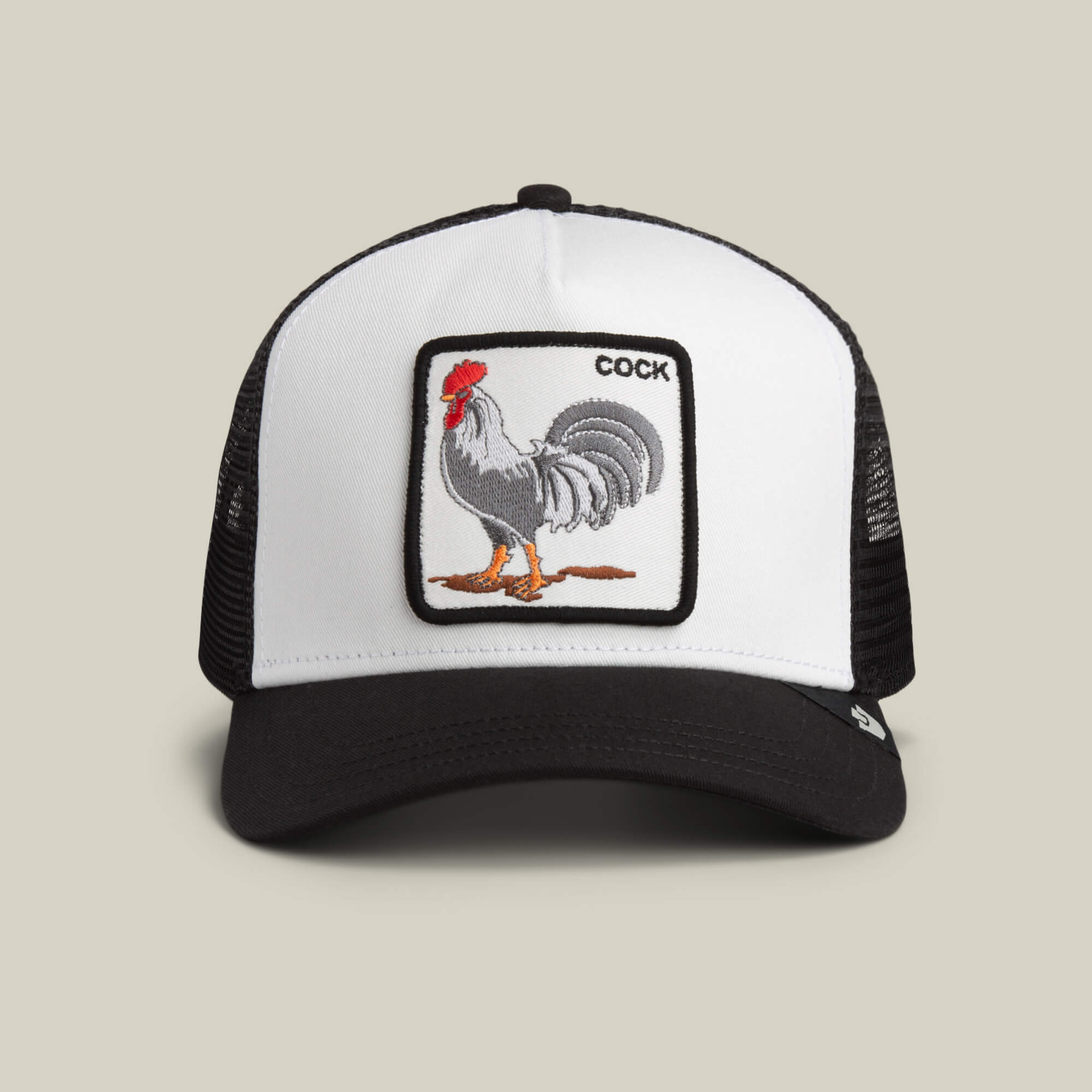 The Goorin Bros. "The Rooster" trucker hat in DUST / VOID features a rectangular rooster patch with the word COCK embroidered in the top right corner.