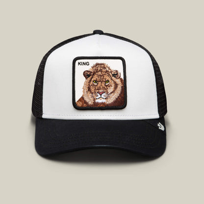The King Trucker by Goorin Bros. is a black and white hat with a bold lion patch and "KING" above it, ideal for power dressing, shown against a simple background.