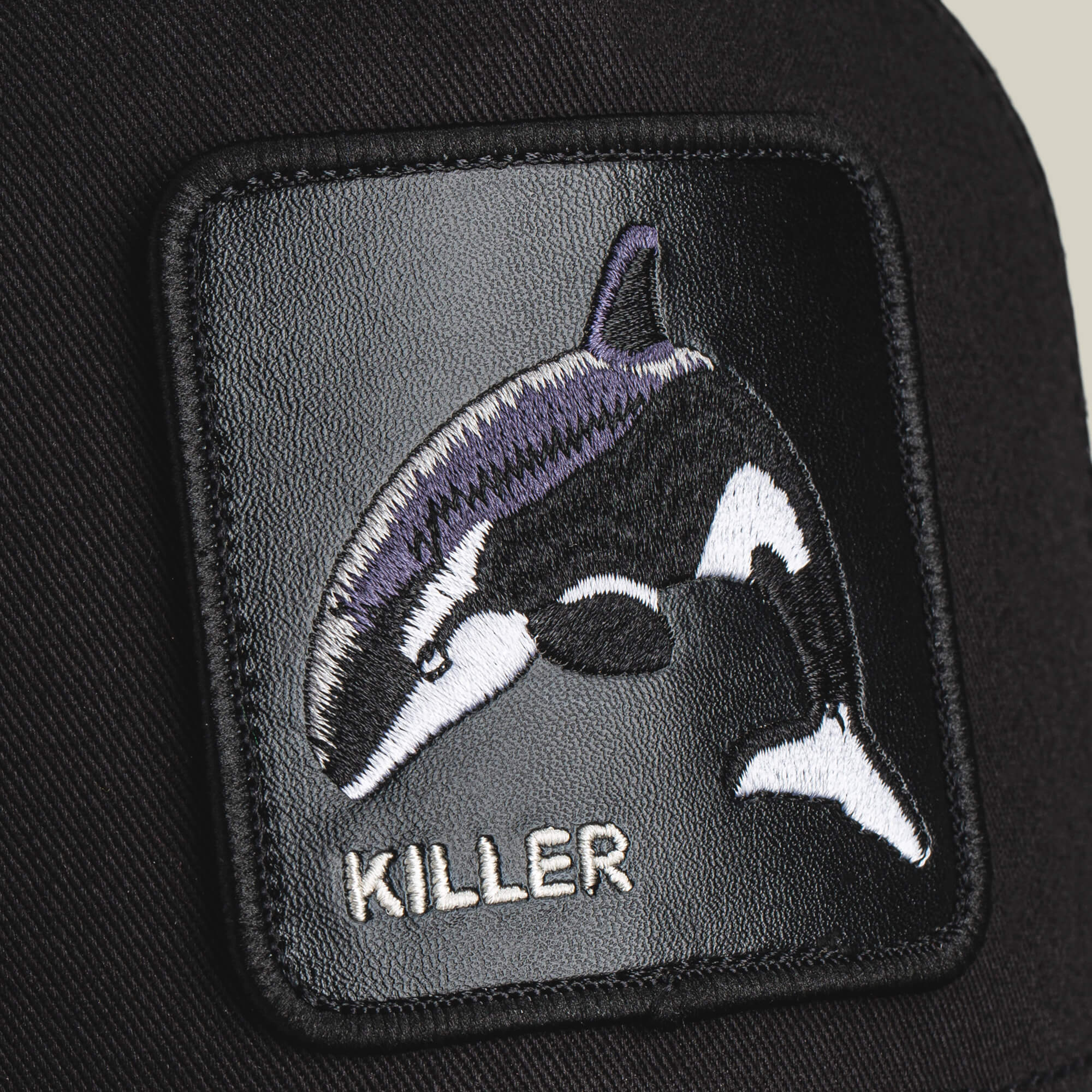 The Killer Trucker by Goorin Bros. sports an embroidered orca with "KILLER" stitched below on a black background—perfect for customizing your favorite black and white cap with bold, apex style.