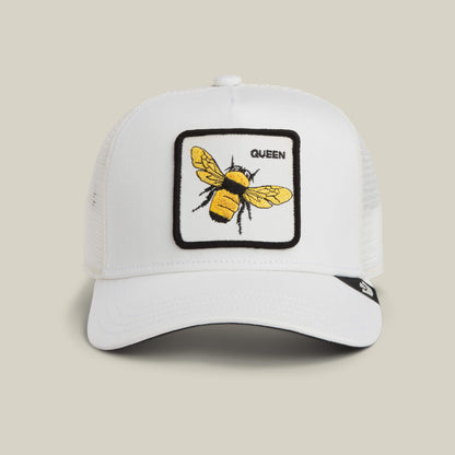 The Queen Trucker by Goorin Bros. is a DUST-colored mesh baseball cap featuring a queen bee patch with an embroidered yellow and black bee and the word "QUEEN" on the front.