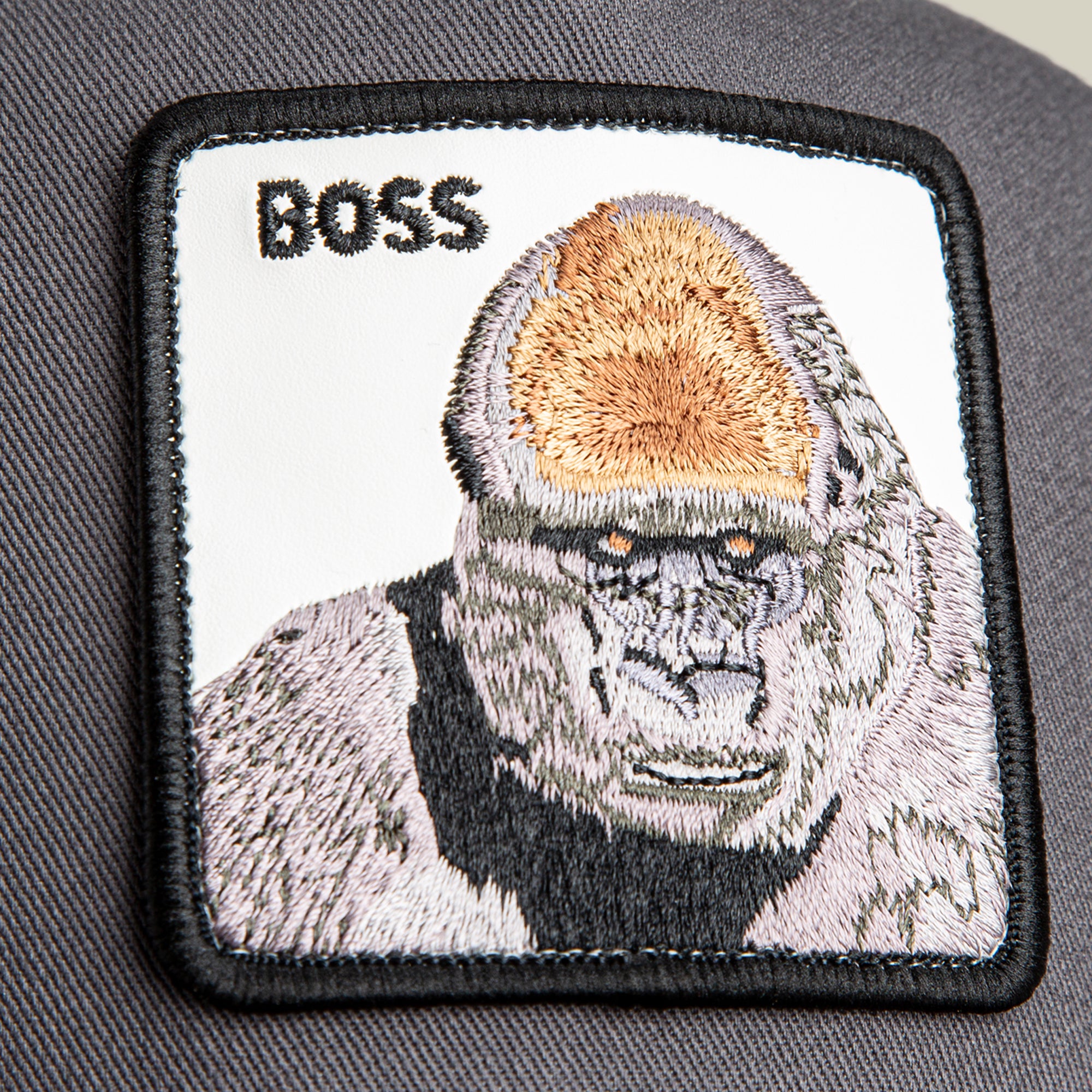 The Boss Trucker by Goorin Bros. features a rectangular fabric patch with an embroidered gorilla and "BOSS" above it, sewn on a dark background—ideal for customizing your hat or showcasing your power moves style.