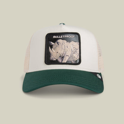 The Bulletproof Trucker by Goorin Bros. is a stylish hat with a green brim, beige mesh, and a front patch of a rhinoceros with "BULLETPROOF," embodying true Rhino armor style.