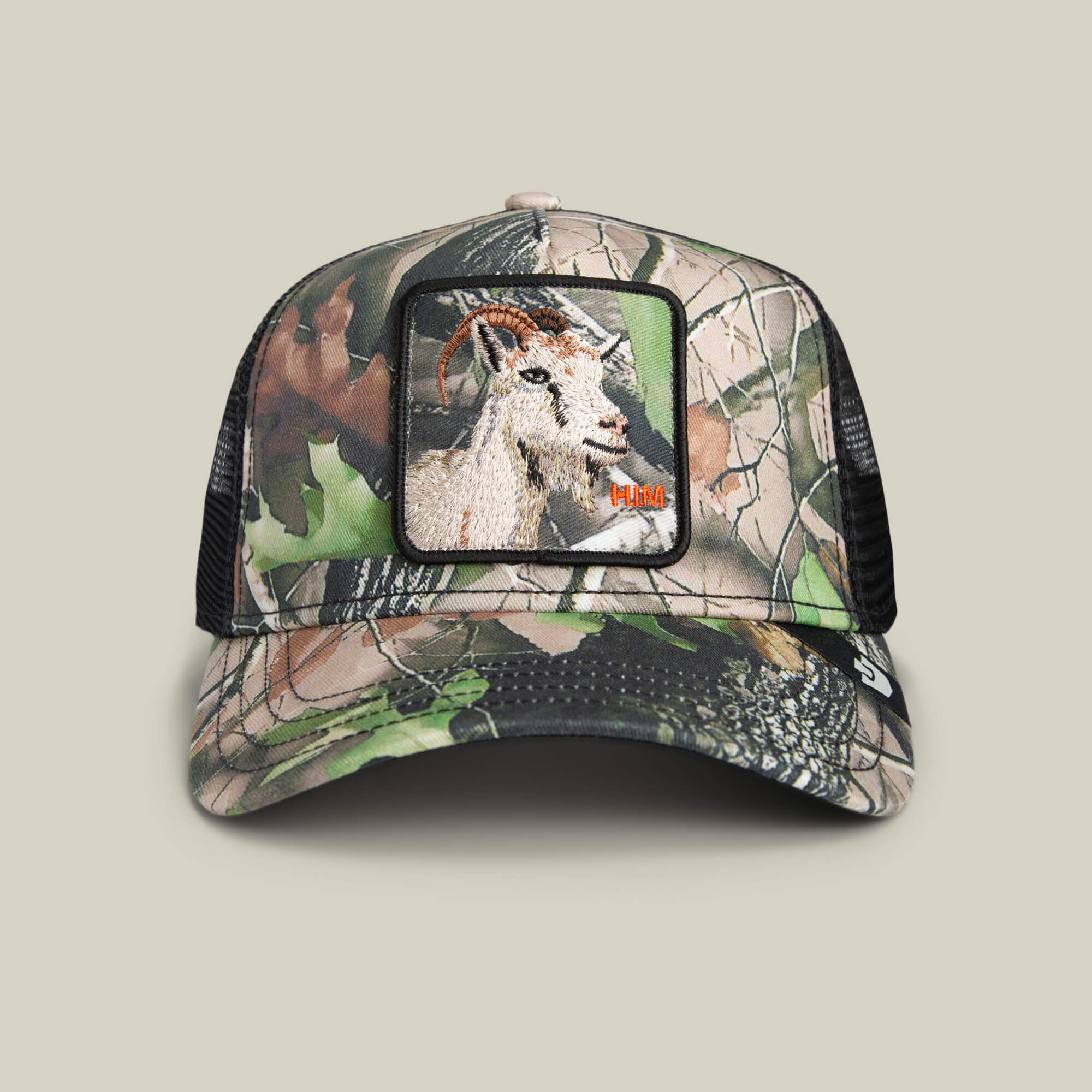 The Goorin Bros. Camouflage Goat hat features a forest camo design, mesh back, and a front patch with an embroidered goat—ideal for outdoor adventures.