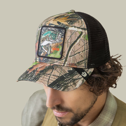 A man wearing the Goorin Bros. Camouflage Bass mesh trucker hat featuring a hyperrealistic embroidered bass patch on the front.