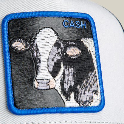 Close-up of the Goorin Bros. "Tricolor Cow" patch, embroidered on white fabric with a blue border—a unique accessory for wallet or cow lovers.
