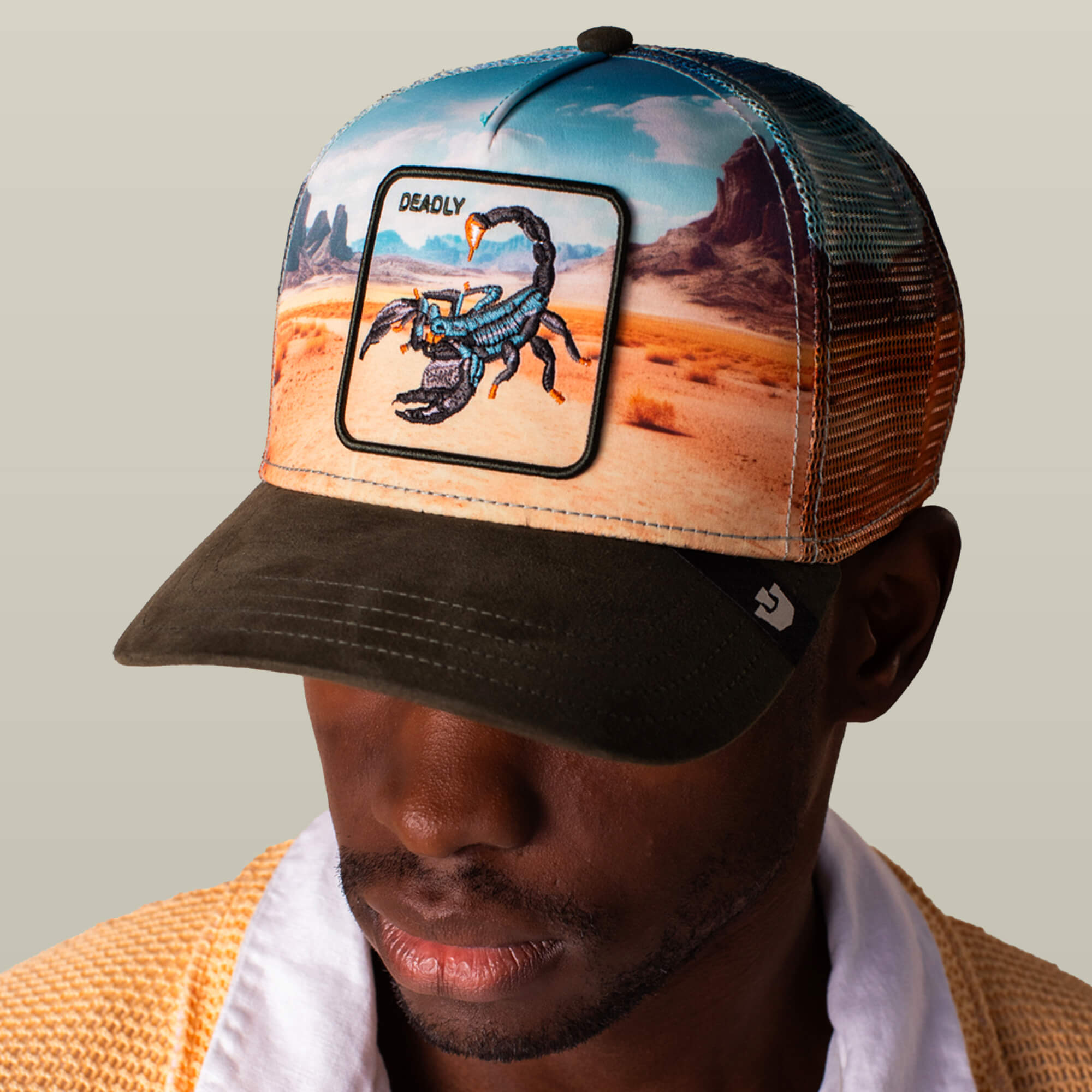 A person wears the Goorin Bros. "Scorpion In The Element" hat, featuring a scorpion patch, "DEADLY" embroidered on the front, and a breathable mesh back for comfort.