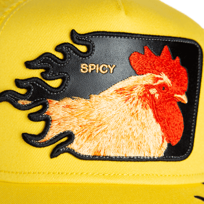Close-up of the Goorin Bros. “Spicy Flames” trucker hat, showcasing an embroidered rooster patch, bold spicy flames, and "SPICY" in gold text.